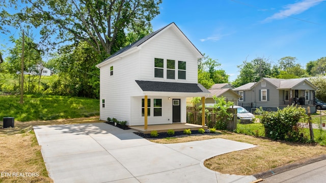 modern farmhouse style home with central AC unit, driveway, a porch, and a shingled roof