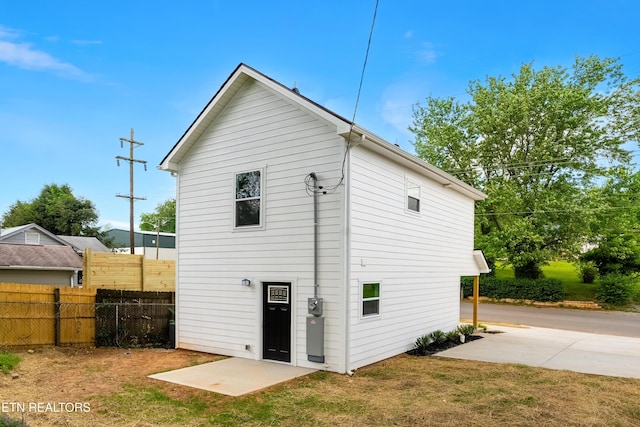 back of house with a lawn and fence