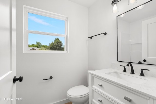 bathroom featuring vanity, toilet, and baseboards