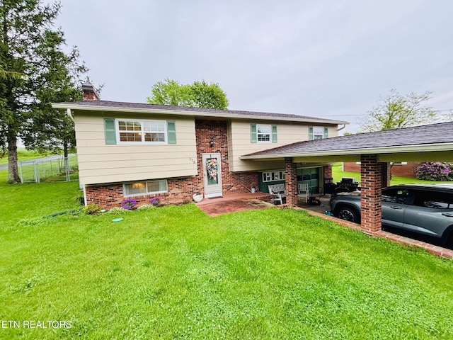 view of front of home with brick siding, a front lawn, a chimney, and an attached carport