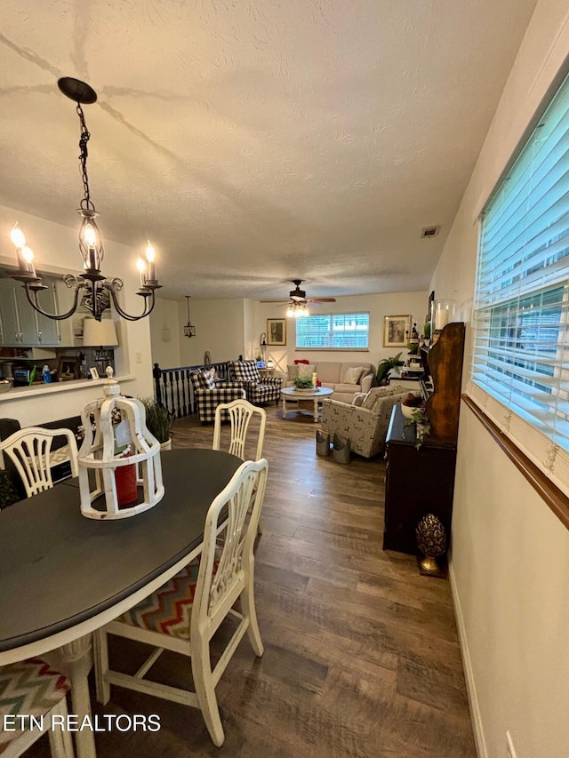 dining area with a ceiling fan, visible vents, a textured ceiling, and wood finished floors