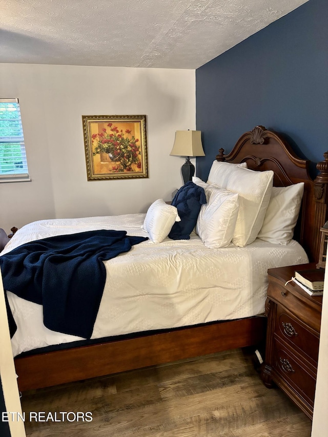 bedroom featuring a textured ceiling and wood finished floors