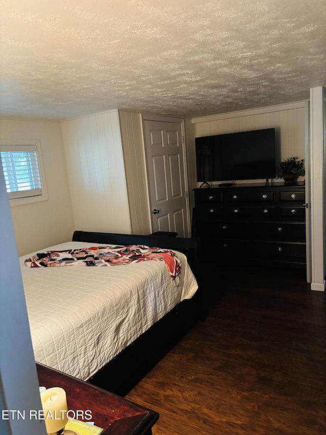 bedroom with a textured ceiling and wood finished floors