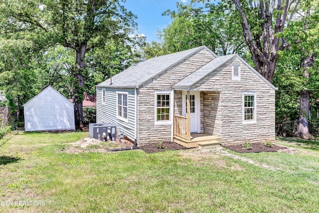 2423 Mccroskey Ave, Knoxville, TN 37917 - view of front of house with stone siding, a shed, an outbuilding, and central air condition unit