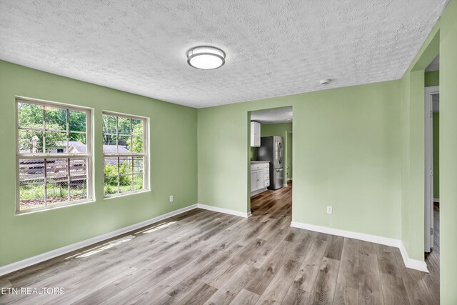 2423 Mccroskey Ave, Knoxville, TN 37917 - empty room with a textured ceiling, baseboards, and wood finished floors