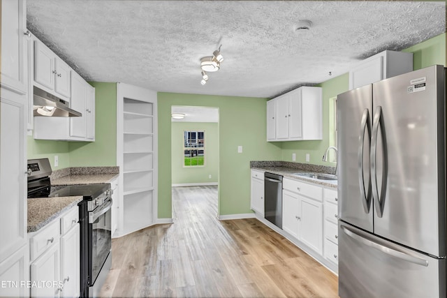 2423 Mccroskey Ave, Knoxville, TN 37917 - kitchen with appliances with stainless steel finishes, a sink, under cabinet range hood, white cabinets, and a textured ceiling