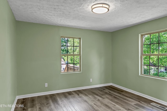 2423 Mccroskey Ave, Knoxville, TN 37917 - empty room with healthy amount of natural light, wood finished floors, baseboards, and a textured ceiling