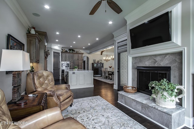 180 Edgewater Way, Lenoir City, TN 37772 - living room with a fireplace, ceiling fan, crown molding, dark wood-type flooring, and arched walkways