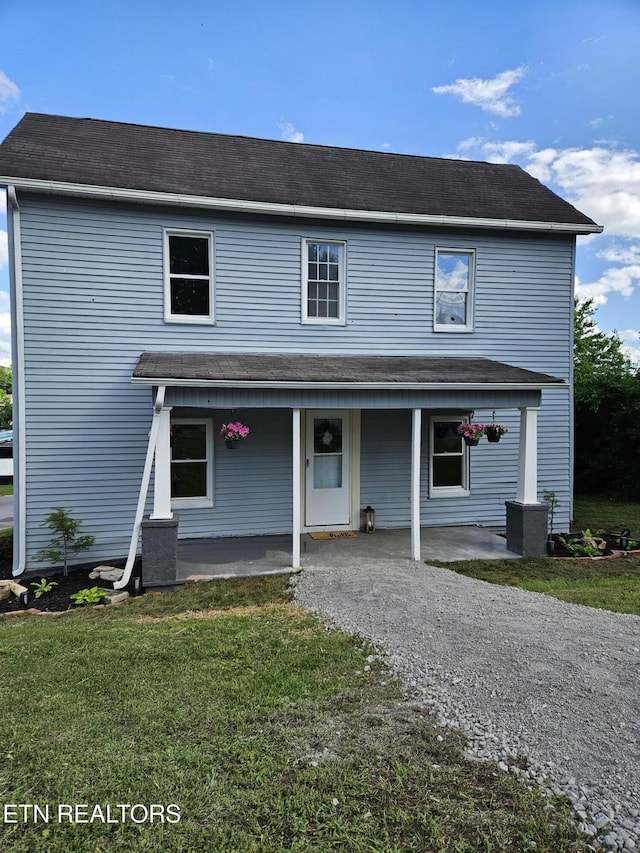 traditional-style house with a porch and a front lawn