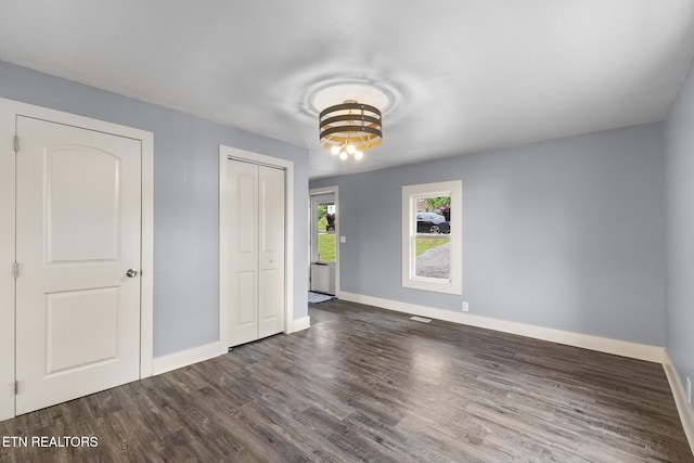 501 Ferry St, Loudon, TN 37774 - unfurnished bedroom featuring baseboards, dark wood finished floors, a closet, and a chandelier