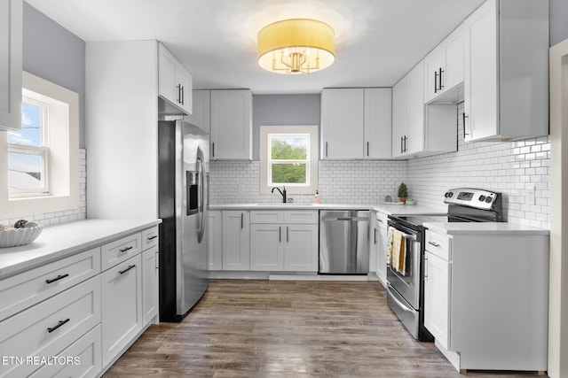 501 Ferry St, Loudon, TN 37774 - kitchen featuring stainless steel appliances, a sink, wood finished floors, white cabinetry, and backsplash