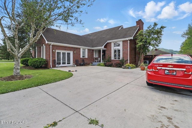 523 N 30th St, Middlesboro, KY 40965 - view of front of house featuring brick siding, a chimney, french doors, a front yard, and driveway