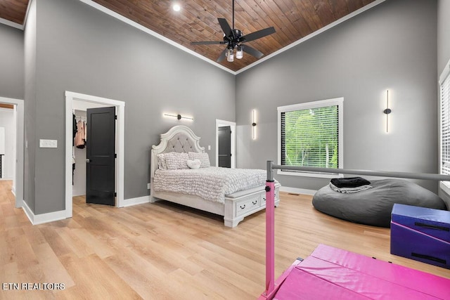 bedroom featuring crown molding, baseboards, and high vaulted ceiling