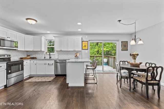 10212 Birch Hill Ln, Knoxville, TN 37932 - kitchen with stainless steel appliances, decorative backsplash, white cabinetry, light stone counters, and dark wood-type flooring