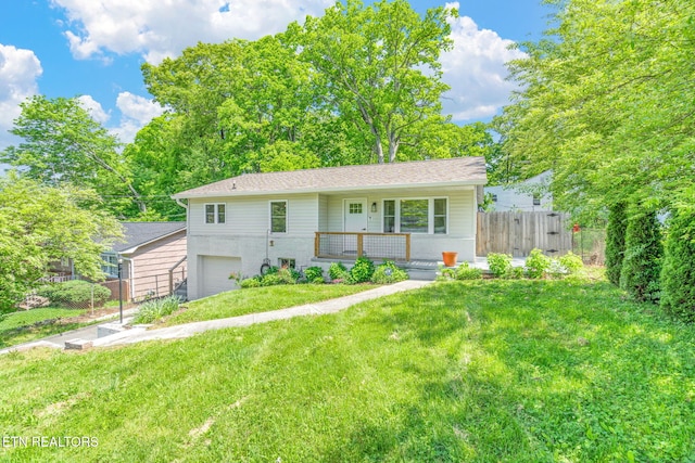 view of front of property with covered porch, fence, a garage, and a front yard