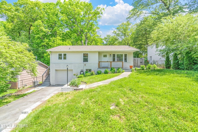 view of front facade with fence, a garage, concrete driveway, a front yard, and a porch