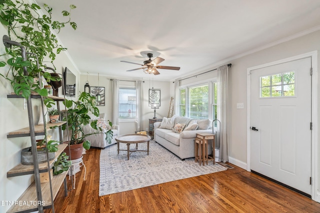 living area with crown molding, baseboards, a ceiling fan, and wood finished floors
