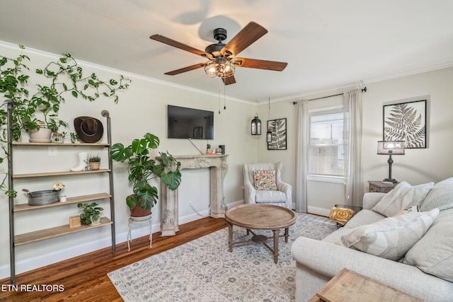 living room featuring crown molding, wood finished floors, baseboards, and ceiling fan