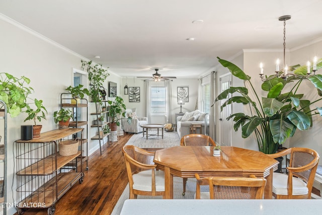 dining area with baseboards, ceiling fan with notable chandelier, ornamental molding, and dark wood-style floors