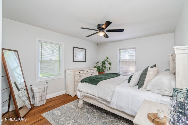bedroom featuring wood finished floors, baseboards, and ceiling fan