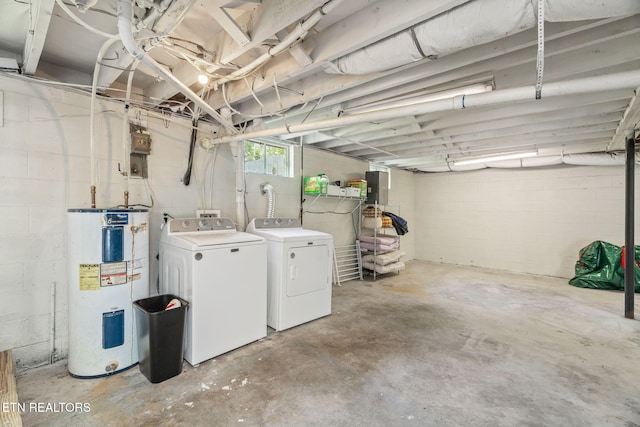 basement featuring washer and dryer, water heater, and electric panel