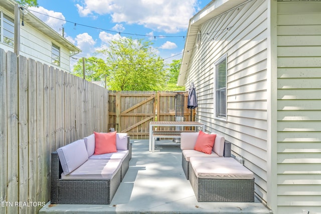 view of patio / terrace with a gate, fence, and an outdoor living space