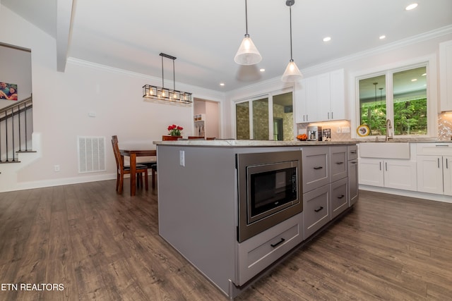 8304 Davis Ferry Rd, Loudon, TN 37774 - kitchen with a sink, white cabinetry, visible vents, stainless steel microwave, and ornamental molding