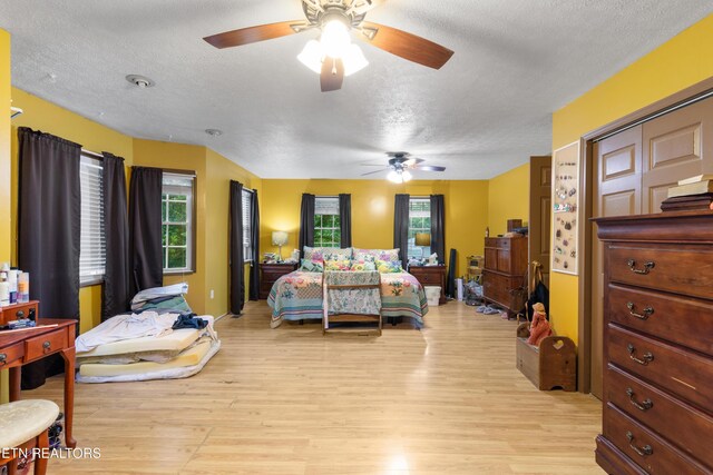 217 Jackson Dr, Harriman, TN 37748 - bedroom featuring a textured ceiling, light wood-style floors, multiple windows, and a ceiling fan