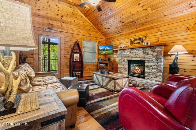 614 Hillybilly Haven Way, Gatlinburg, TN 37738 - living room featuring wood finished floors, a ceiling fan, a stone fireplace, wooden ceiling, and wooden walls