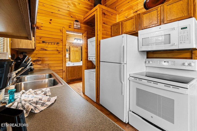 614 Hillybilly Haven Way, Gatlinburg, TN 37738 - kitchen featuring a sink, stacked washer and clothes dryer, white appliances, and wooden walls