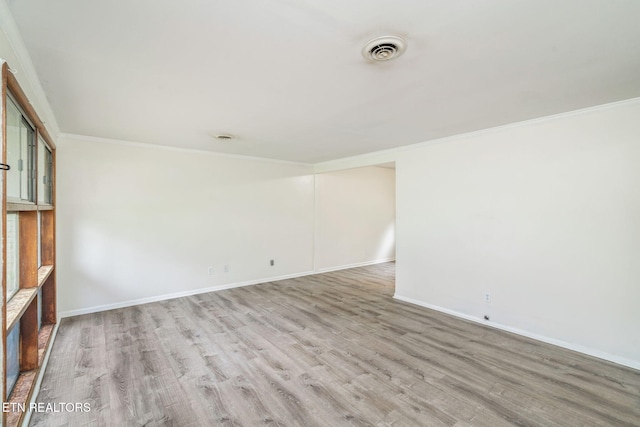 unfurnished room featuring ornamental molding, light wood finished floors, and baseboards