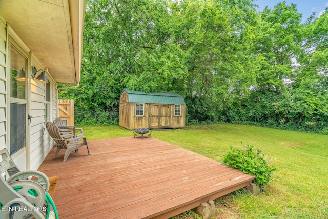 wooden terrace featuring a storage shed, an outdoor structure, and view of scattered trees