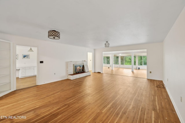 138 Lilac Dr, Lafollette, TN 37766 - unfurnished living room with light wood-type flooring, a fireplace, and baseboards