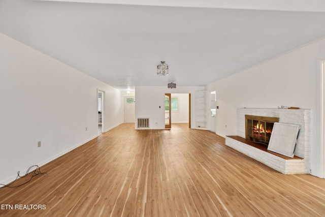 138 Lilac Dr, Lafollette, TN 37766 - unfurnished living room with light wood-style floors, a fireplace, and baseboards
