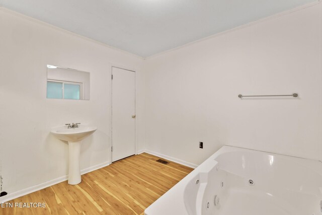 138 Lilac Dr, Lafollette, TN 37766 - full bathroom featuring wood finished floors, a jetted tub, crown molding, baseboards, and a sink