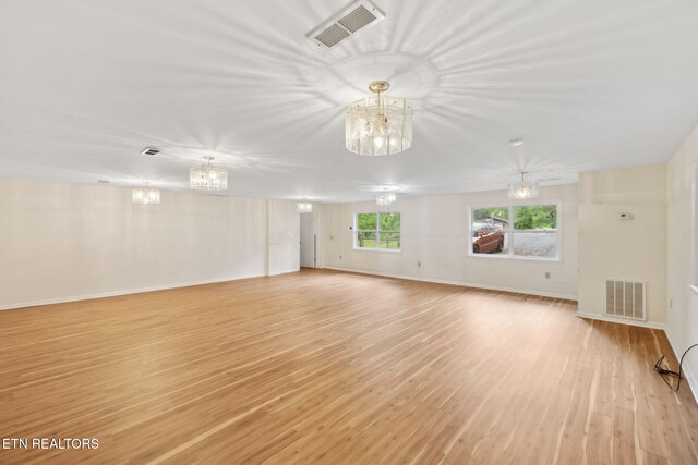 138 Lilac Dr, Lafollette, TN 37766 - unfurnished living room with a chandelier, light wood-style flooring, and baseboards