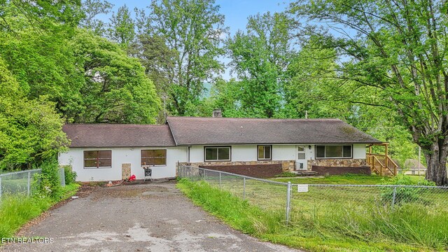 138 Lilac Dr, Lafollette, TN 37766 - ranch-style home featuring asphalt driveway, a chimney, stone siding, stucco siding, and roof with shingles