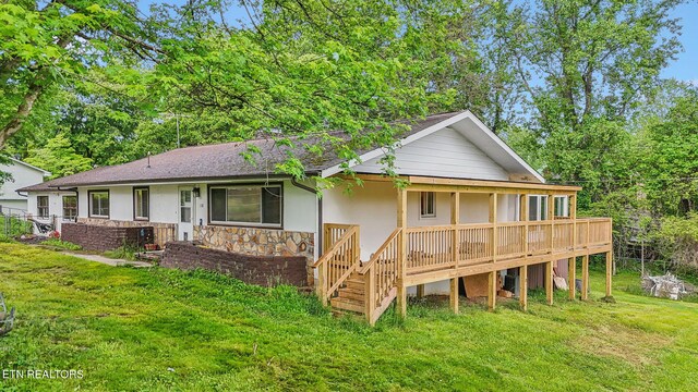 138 Lilac Dr, Lafollette, TN 37766 - back of property with a yard, stone siding, stucco siding, a shingled roof, and a deck