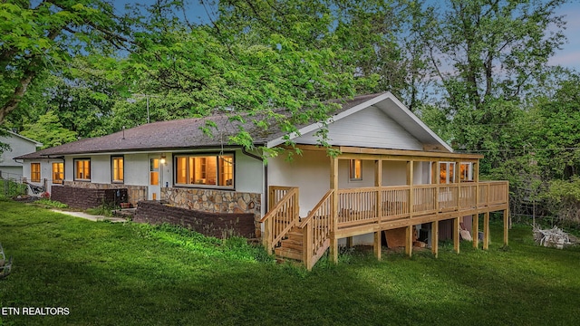 138 Lilac Dr, Lafollette, TN 37766 - back of property featuring a lawn, stucco siding, stone siding, and roof with shingles