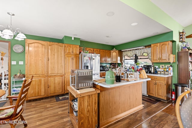 kitchen featuring stainless steel fridge with ice dispenser, light countertops, a chandelier, a center island, and wood finished floors