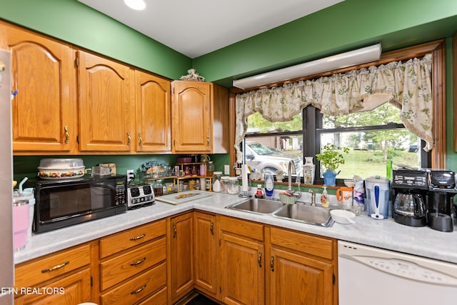 kitchen with dishwasher, black microwave, a sink, and light countertops
