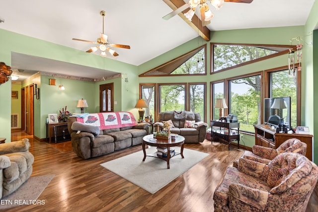 living area with ceiling fan, beamed ceiling, wood finished floors, and high vaulted ceiling
