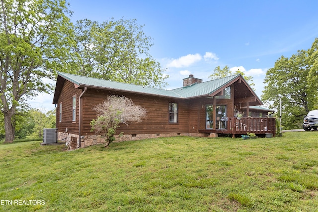 rear view of house featuring a deck, a yard, crawl space, a chimney, and metal roof