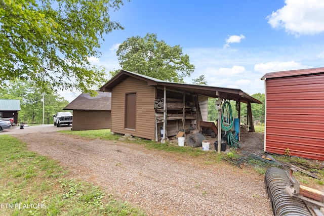 view of outdoor structure featuring dirt driveway and an outdoor structure