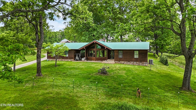 rustic home featuring metal roof and a front yard