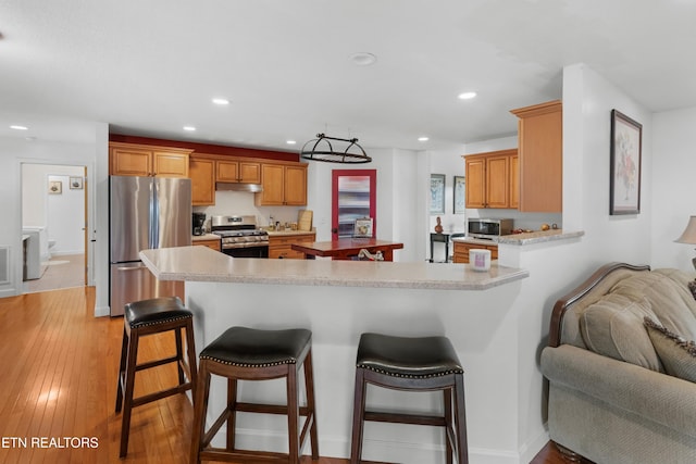 687 Burchfield Rd, Dandridge, TN 37725 - kitchen featuring stainless steel appliances, light countertops, under cabinet range hood, a breakfast bar, and recessed lighting