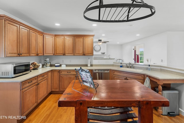 687 Burchfield Rd, Dandridge, TN 37725 - kitchen featuring stainless steel appliances, a sink, light wood-type flooring, light countertops, and brown cabinetry