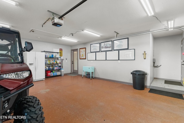 687 Burchfield Rd, Dandridge, TN 37725 - garage featuring white refrigerator with ice dispenser, a garage door opener, and baseboards
