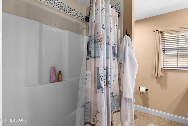 bathroom featuring baseboards, tile patterned floors, and a shower with shower curtain