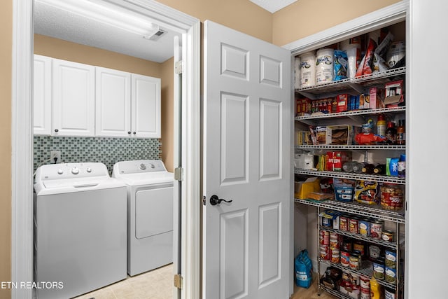 laundry area with washer and clothes dryer and cabinet space